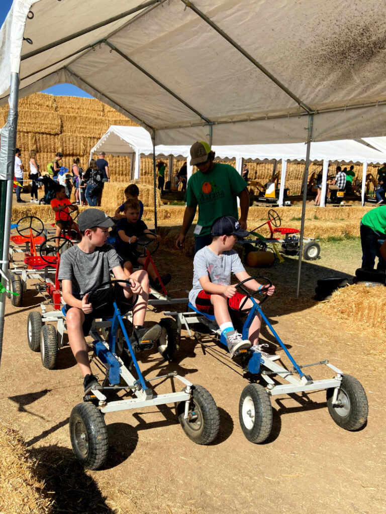kids sitting on pedal carts ready to start a race