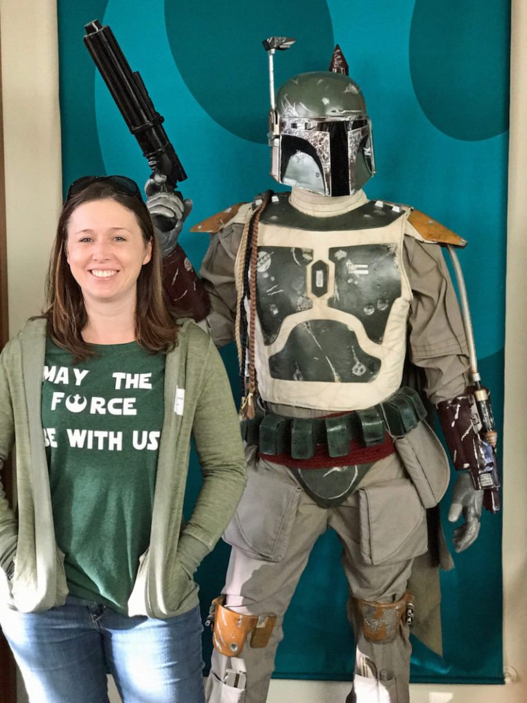 woman standing with a boba fett statue
