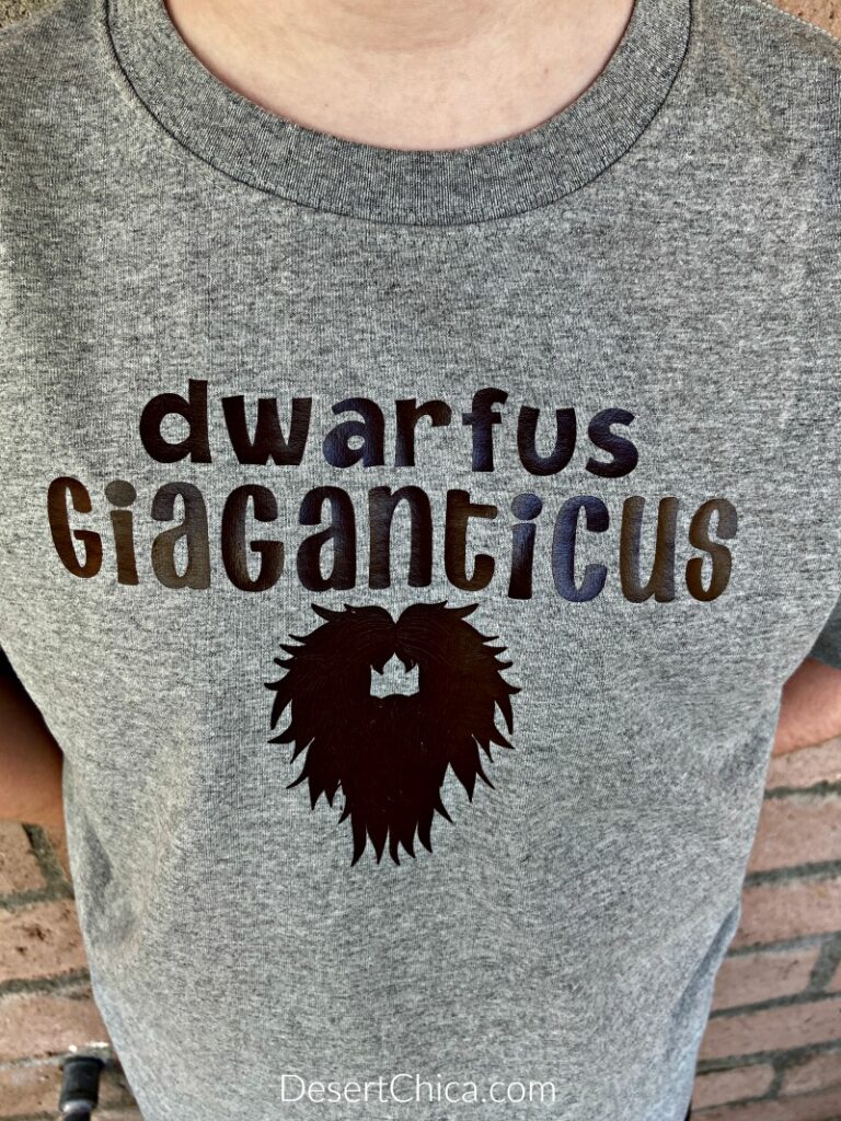 grey t-shirt featuring a brown design of a dwarf beard that says "dwarfus Giaganticus' inspired by Mulch Diggum from Artemis Fowl