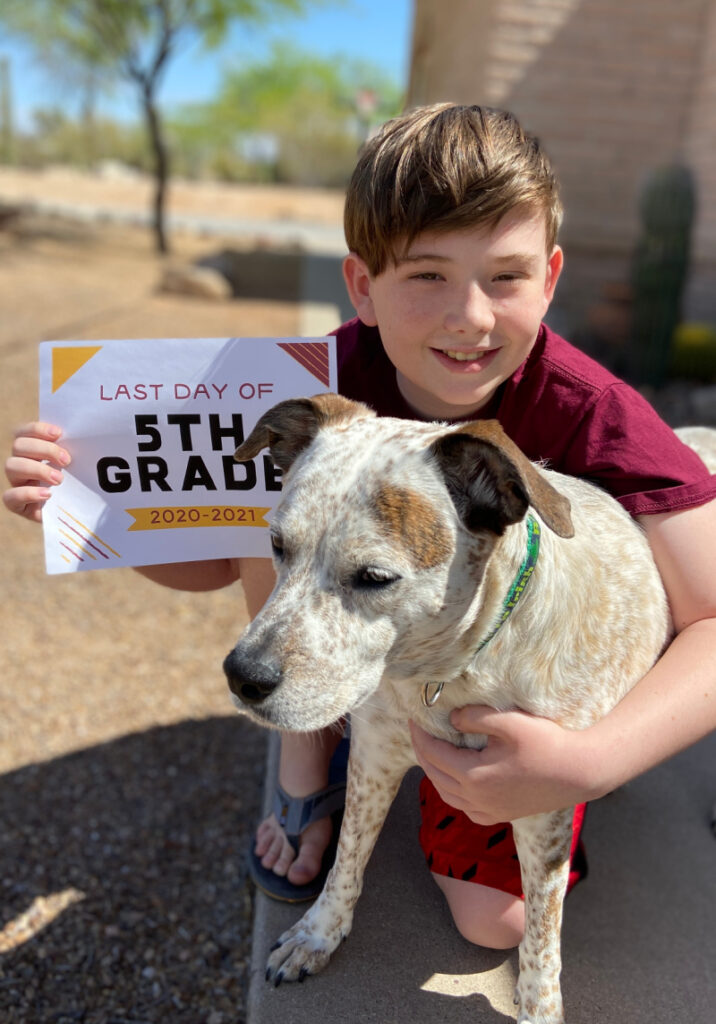 Boy and dog with a last day of 5th grade school sign