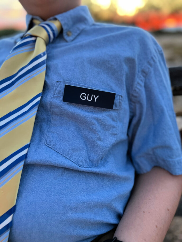 blue and yellow tie and name tag that says "GUY"