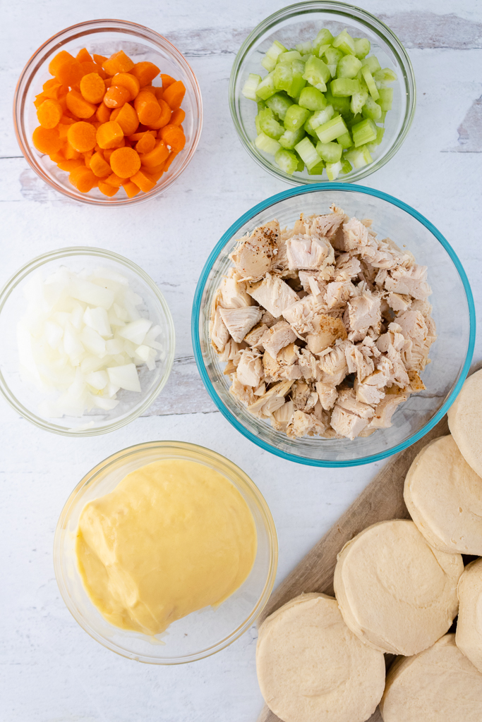 chicken pot pie ingredients including chopped chicken, biscuits, cream of chicken soup, chopped onion, carrots and celery