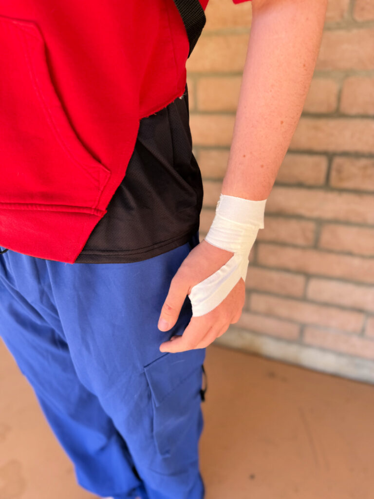 Side view of red hoodie cut on sides for Bombastic Bag-Man Costume