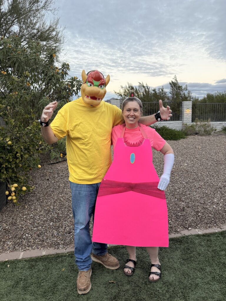 Adults dressed as Princess Peach and Bowser in homemade Super Mario Halloween costumes