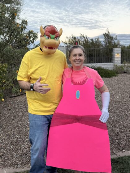 Homemade Princess Peach costume made from pink poster board with a crown and white gloves