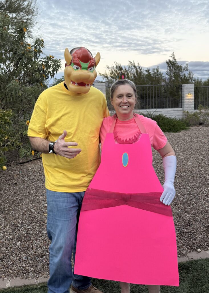 Homemade Princess Peach costume made from pink poster board with a crown and white gloves
