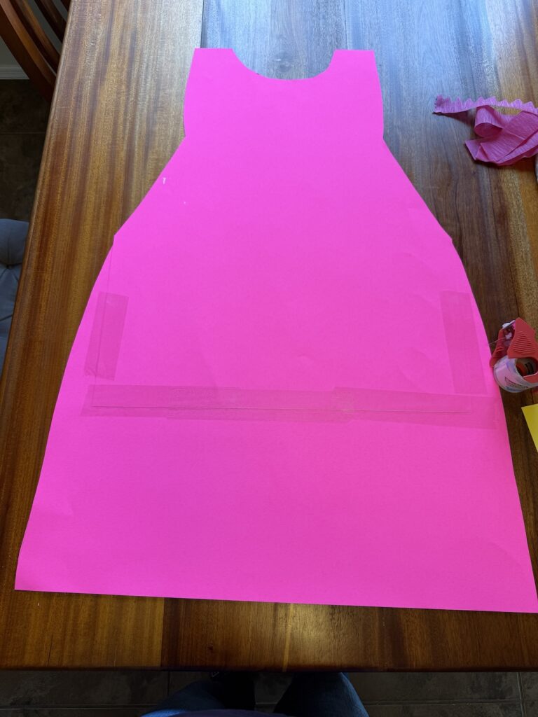 Two pieces of pink poster board cut and joined to create a Princess Peach dress